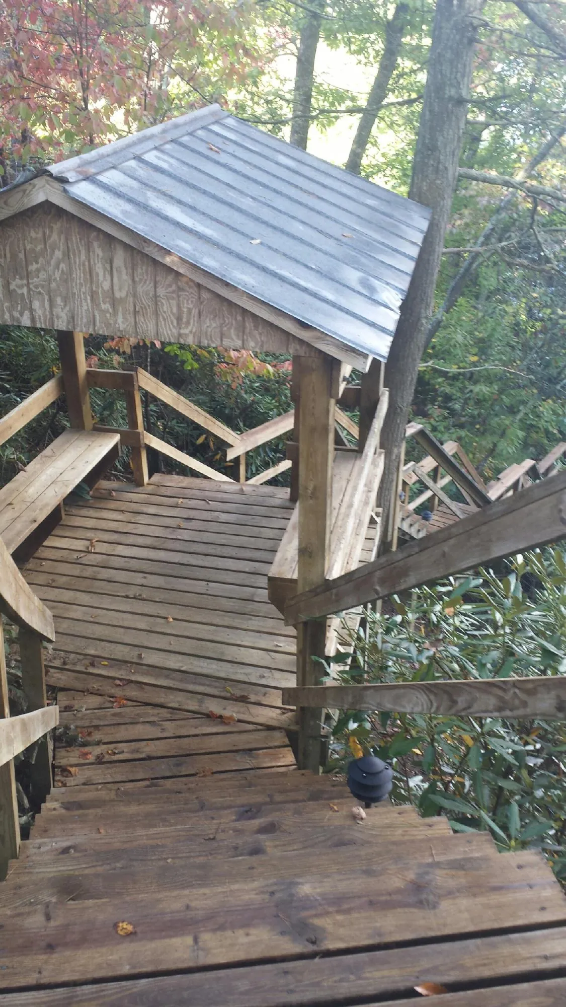 Metal roofed shelter over wooden steps on a wooded walkway — Skylight Repair & Installation work by our crew in Clay Center